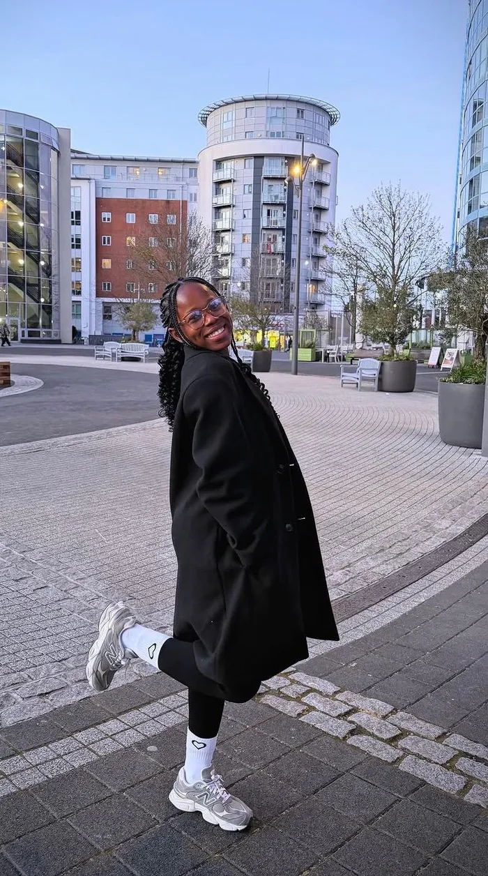 Precious looking back in a black coat